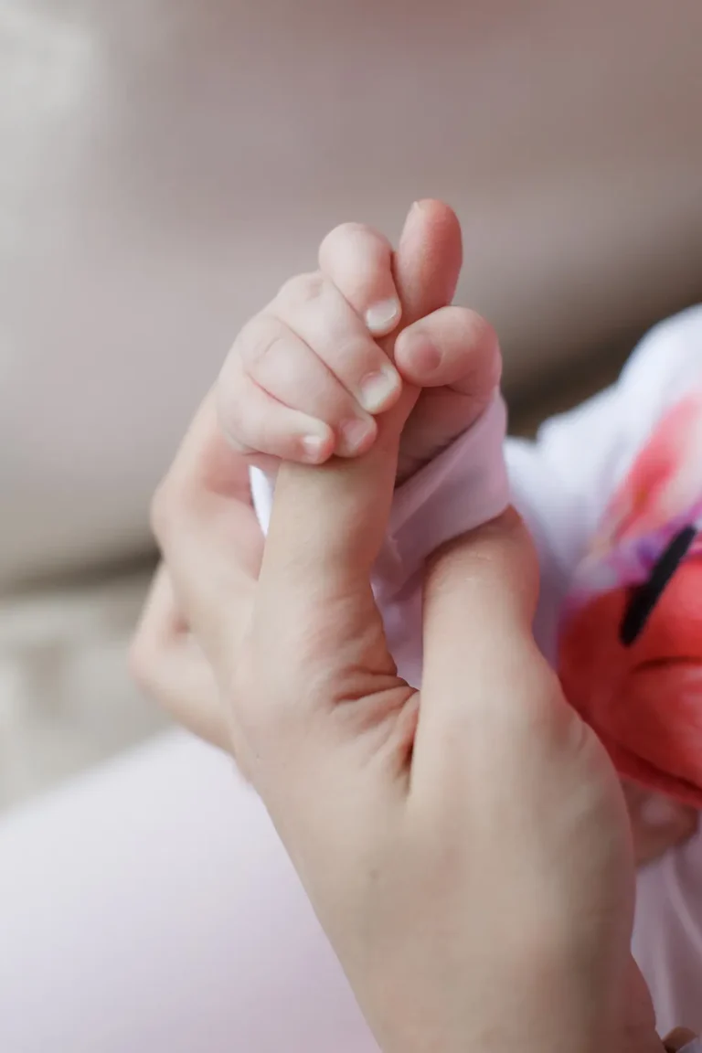 Close-up of tender hands cradling tiny baby feet - Dream IVF Cyprus, Welcoming New Life with Love and Care