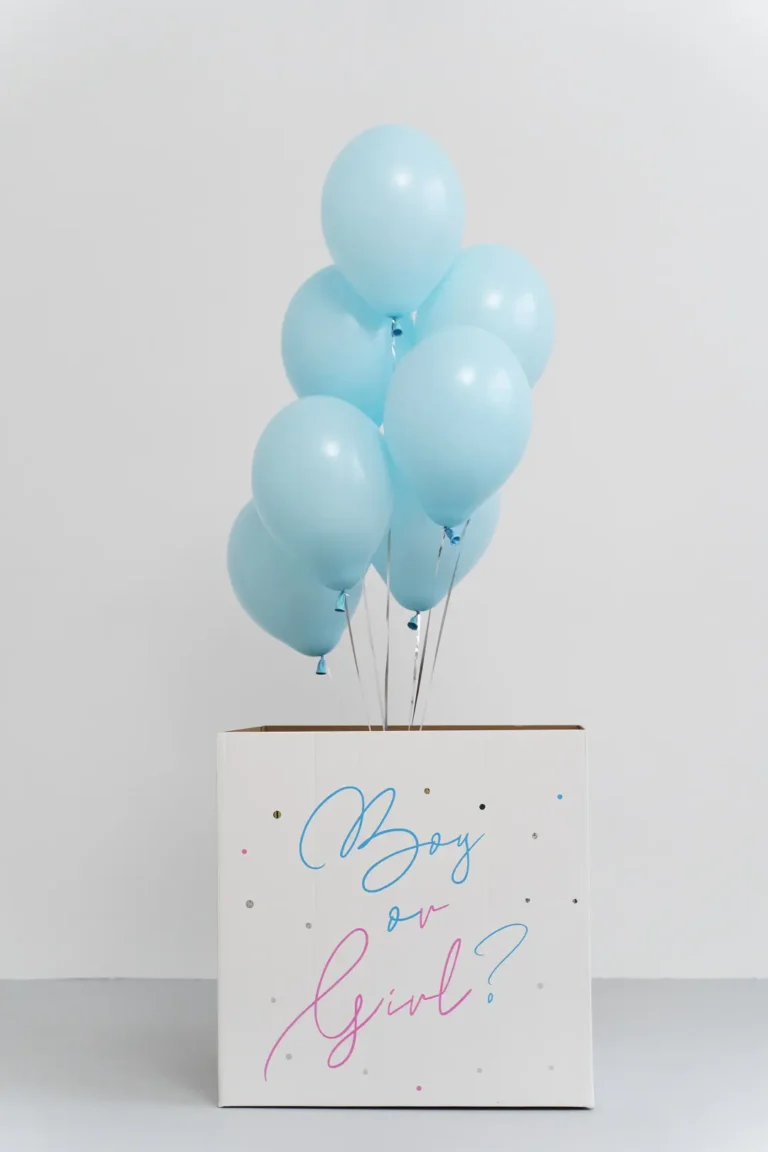 Colorful balloons connected to a box labeled 'Boy or Girl' - Dream IVF Cyprus, Your Path to Parenthood | Gender Reveal Concept